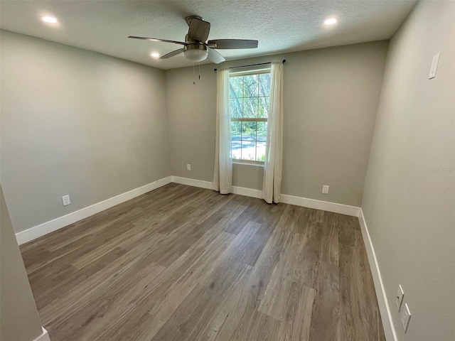 spare room featuring wood finished floors, a ceiling fan, and baseboards