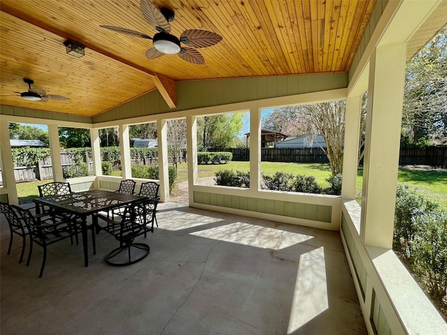 sunroom with vaulted ceiling, ceiling fan, and wooden ceiling