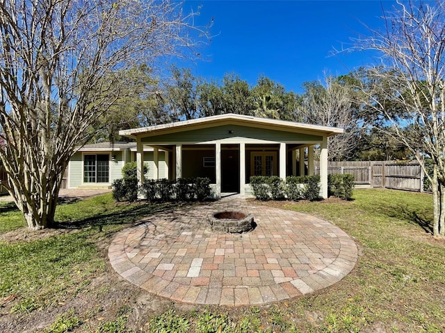 view of front facade featuring a patio area, fence, a fire pit, and a front lawn