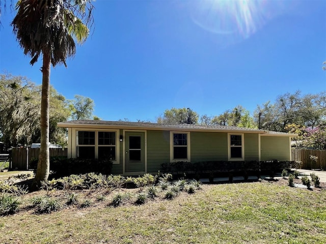 view of front of house with fence and a front lawn