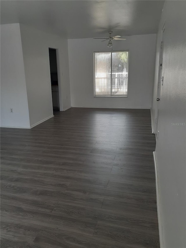 empty room featuring ceiling fan and dark wood-style flooring