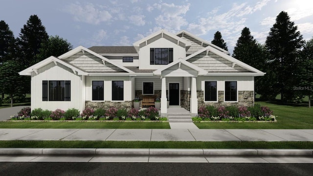 view of front of property featuring stone siding, board and batten siding, and a front yard