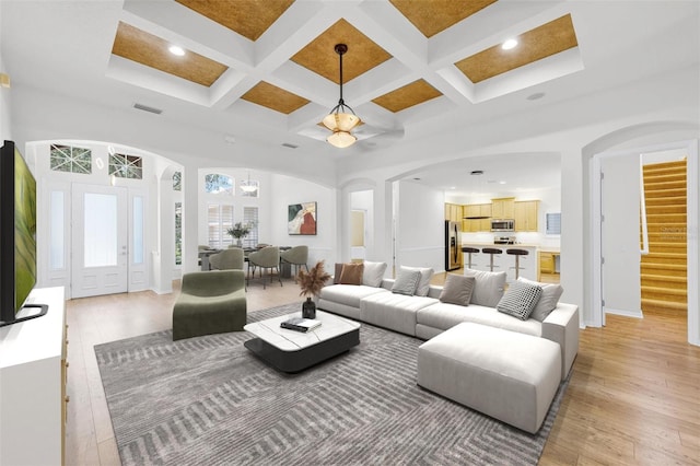 1203 Gatwick Loop, Lake Mary, FL 32746 - living area featuring arched walkways, coffered ceiling, light wood-style flooring, stairway, and recessed lighting