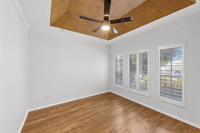 1203 Gatwick Loop, Lake Mary, FL 32746 - empty room featuring wood-type flooring, a tray ceiling, a ceiling fan, ornamental molding, and baseboards