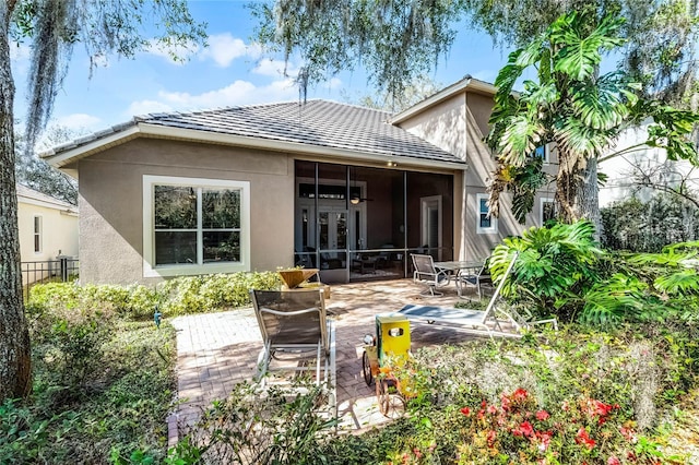 1203 Gatwick Loop, Lake Mary, FL 32746 - rear view of house with stucco siding, a patio area, and a sunroom
