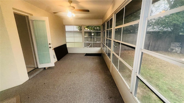 unfurnished sunroom with a ceiling fan