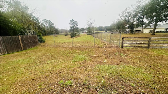 view of yard with fence and a rural view