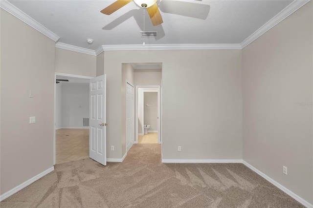 unfurnished room featuring light carpet, baseboards, visible vents, and crown molding