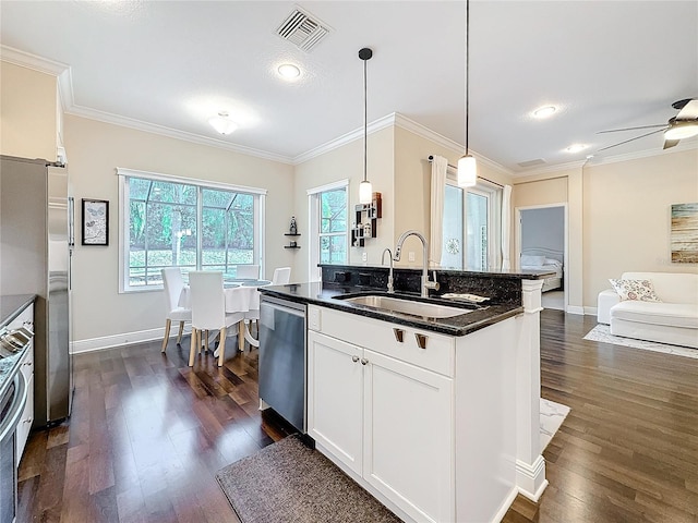 kitchen with visible vents, dishwasher, hanging light fixtures, white cabinetry, and a sink