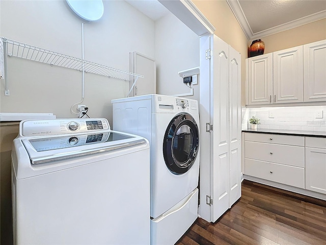 laundry area with ornamental molding, dark wood-type flooring, and washer and dryer