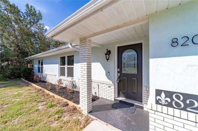 doorway to property with brick siding