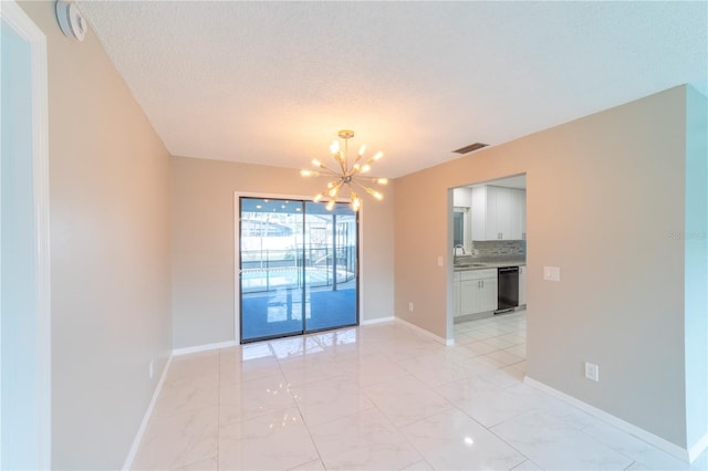 empty room with baseboards, visible vents, marble finish floor, a chandelier, and a sink