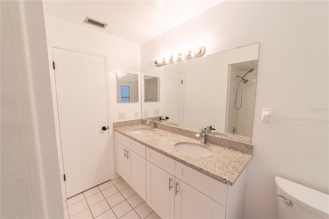 bathroom with toilet, double vanity, a sink, and visible vents