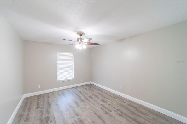 unfurnished room with a ceiling fan, light wood-type flooring, and baseboards