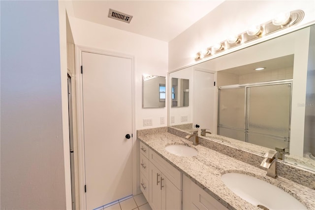 bathroom with an enclosed shower, visible vents, and a sink