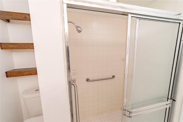 bathroom featuring tiled shower and toilet