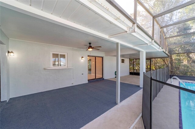 view of patio featuring ceiling fan, glass enclosure, and a fenced in pool