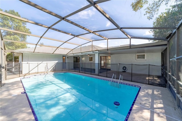 pool with glass enclosure and a patio area