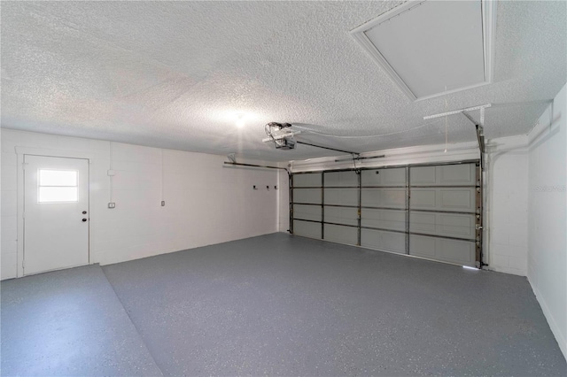 garage featuring a garage door opener and concrete block wall