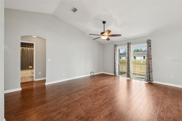 spare room with arched walkways, dark wood-style flooring, lofted ceiling, visible vents, and a ceiling fan