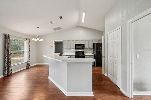 kitchen featuring pendant lighting, a center island with sink, light countertops, visible vents, and black appliances