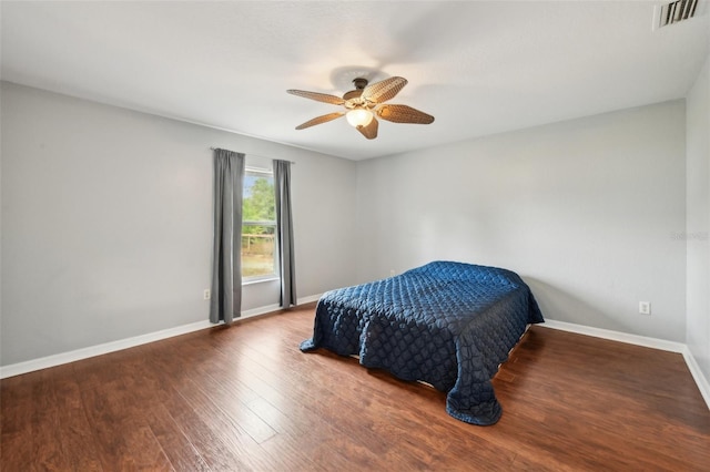 bedroom featuring a ceiling fan, baseboards, visible vents, and wood finished floors