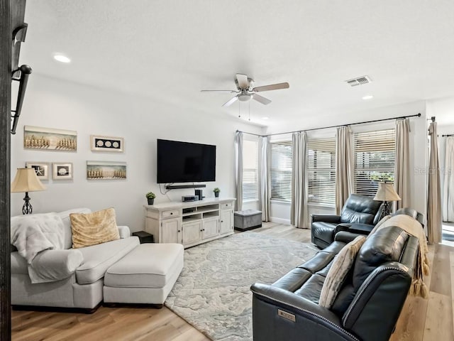 living area with light wood finished floors, a ceiling fan, a wealth of natural light, and recessed lighting