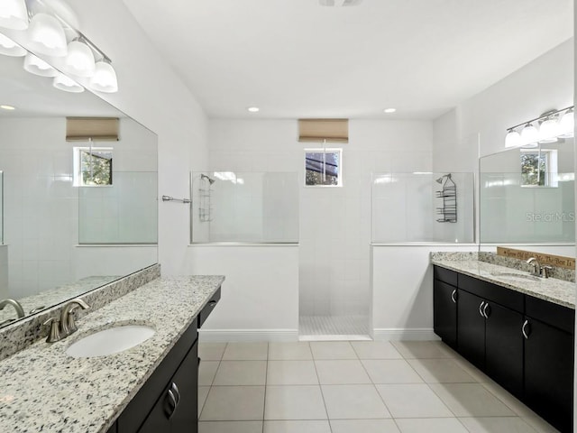 full bathroom featuring tile patterned flooring, two vanities, walk in shower, and a sink