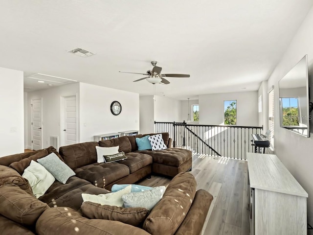 living area featuring visible vents and wood finished floors