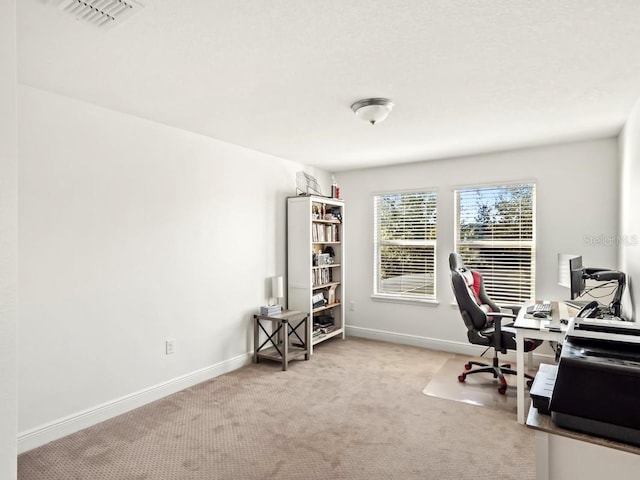 home office with light carpet, baseboards, and visible vents