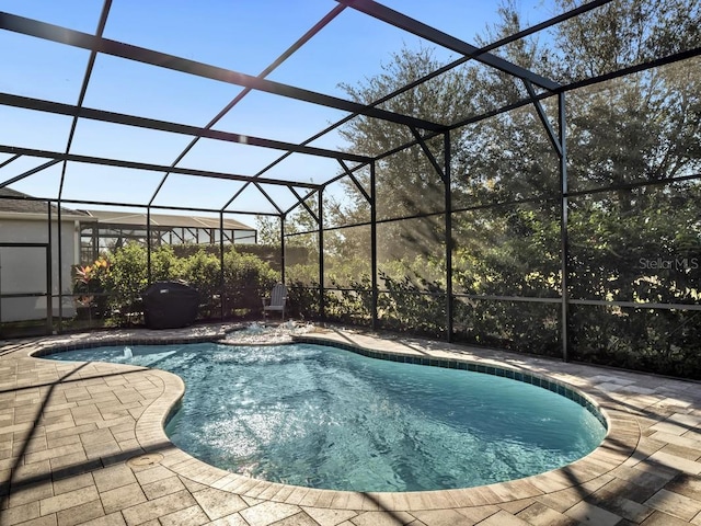 pool featuring a patio area and glass enclosure