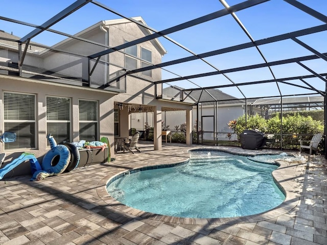 pool featuring glass enclosure, a patio area, and outdoor lounge area