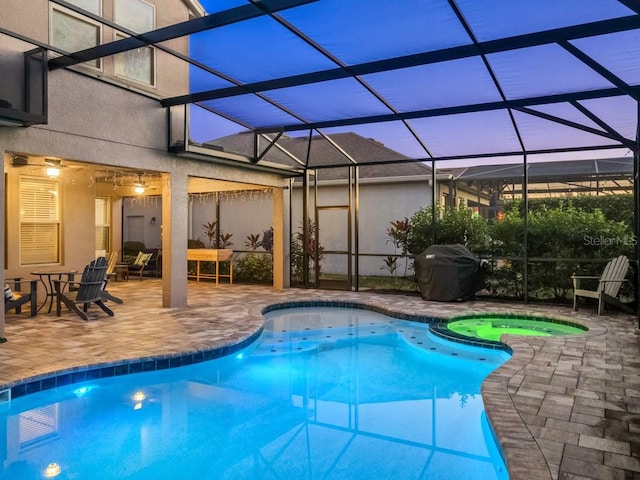 view of swimming pool with a lanai, a patio area, a pool with connected hot tub, and area for grilling