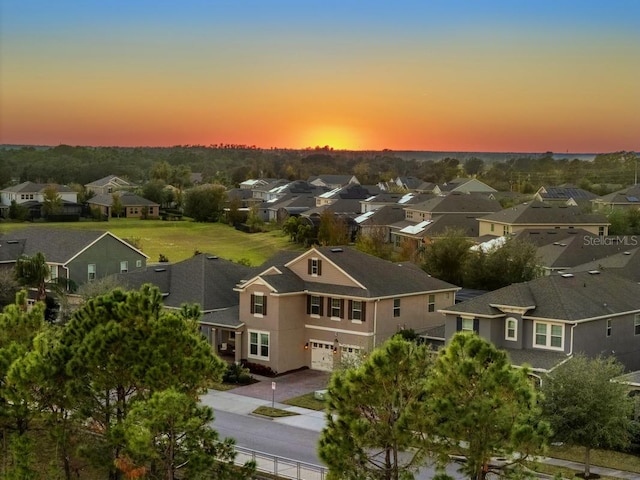 aerial view at dusk featuring a residential view