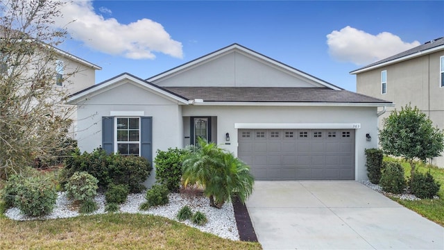 single story home with a shingled roof, concrete driveway, an attached garage, and stucco siding