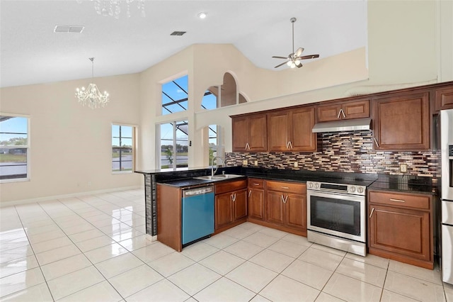 kitchen with under cabinet range hood, stainless steel appliances, a sink, brown cabinetry, and dark countertops