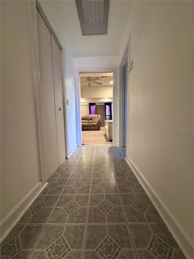 hallway featuring visible vents and baseboards