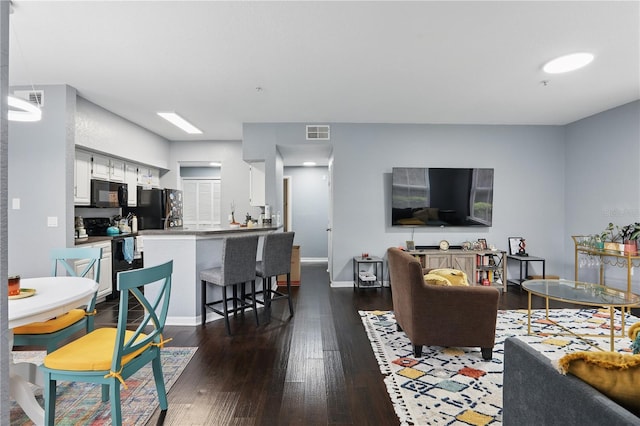 living room featuring baseboards, visible vents, and dark wood-type flooring