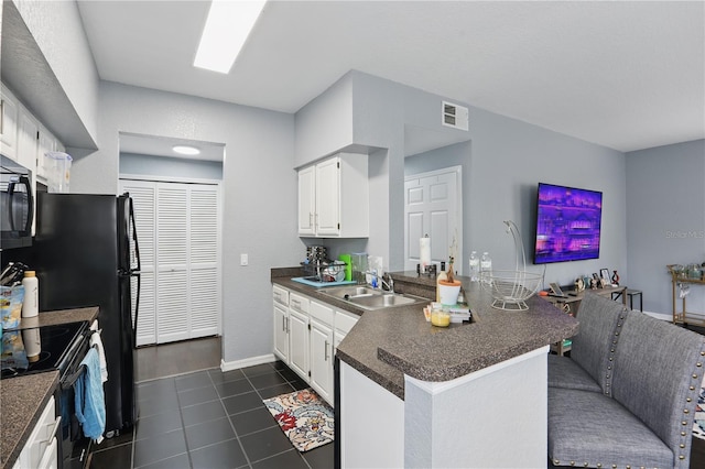 kitchen with visible vents, dark countertops, black electric range oven, a peninsula, and a sink