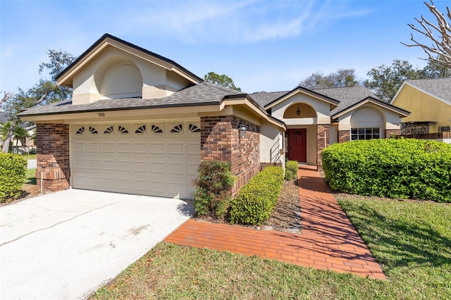 view of front of property featuring stucco siding, brick siding, and driveway