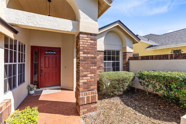 property entrance with brick siding and stucco siding