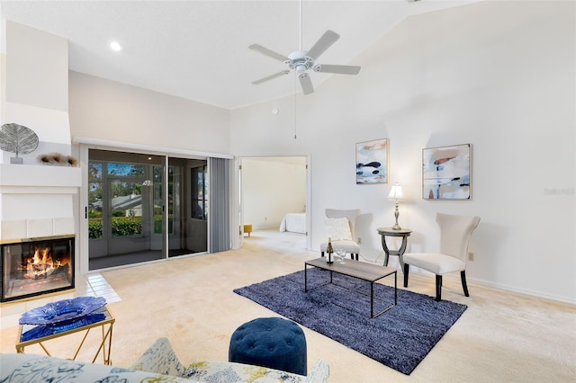 living area featuring carpet, baseboards, high vaulted ceiling, a fireplace, and ceiling fan