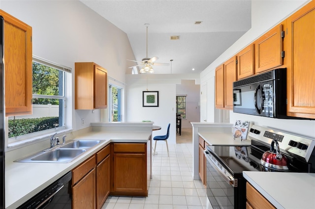 kitchen with a sink, black appliances, and light countertops