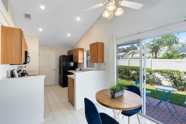 kitchen with visible vents, light countertops, brown cabinets, light tile patterned flooring, and black appliances