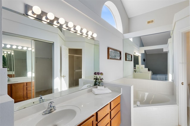 full bath with visible vents, a shower stall, a garden tub, lofted ceiling, and vanity