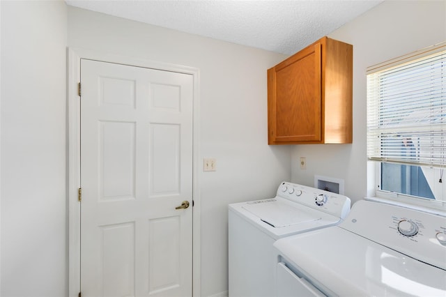 laundry room with washer and dryer, cabinet space, and a textured ceiling