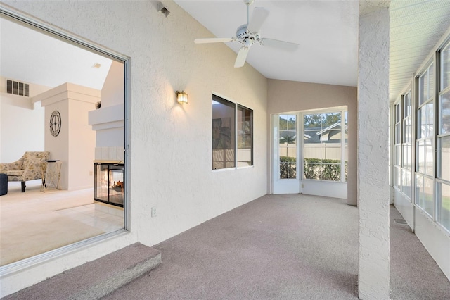 sunroom featuring visible vents, lofted ceiling, and ceiling fan