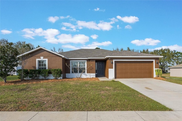 ranch-style home featuring a garage, concrete driveway, a front yard, and stucco siding