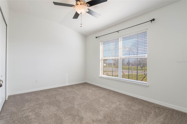 unfurnished room featuring a ceiling fan, carpet flooring, vaulted ceiling, and baseboards