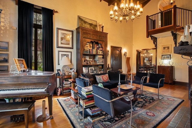 living area with wood finished floors, a healthy amount of sunlight, and an inviting chandelier